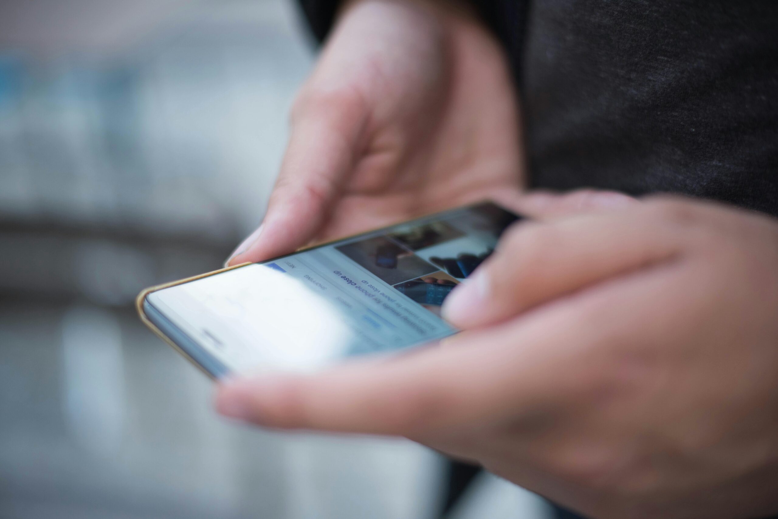 Close-up of hands using a smartphone with a touchscreen, emphasizing mobile technology.